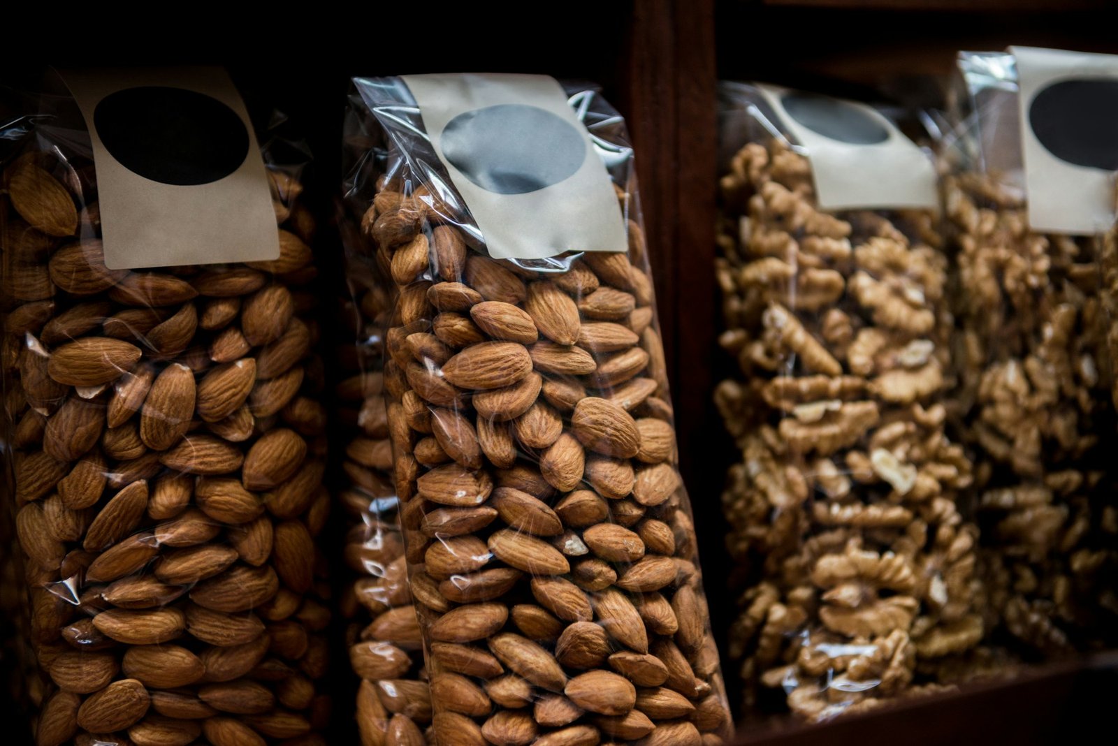 close up view of almonds and walnuts in plastic packaging