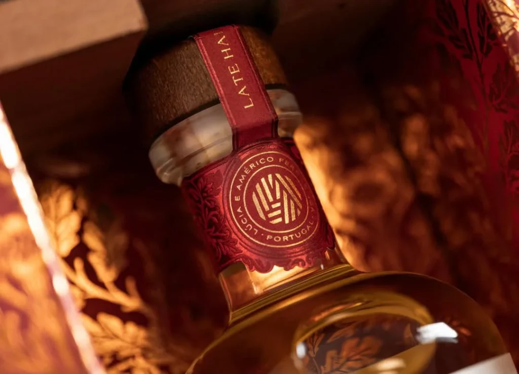 Embalagem de luxo Souvall Vindima Tardia em tom vermelho profundo com detalhes em folha de ouro e acabamento tátil sofisticado.