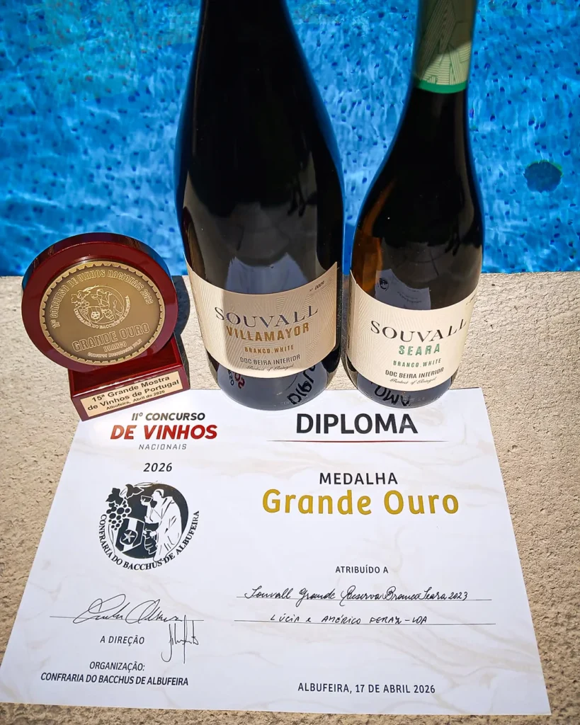 Duas garrafas de vinho Souvall Grande Reserva junto a uma piscina em ambiente de lazer no Algarve.